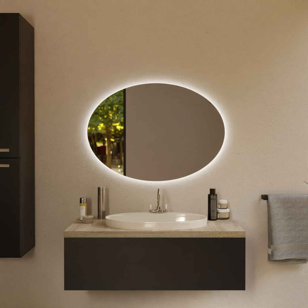 Ovaler Wandspiegel mit LED-Lichtsaum über Waschtisch und rundem Waschbecken