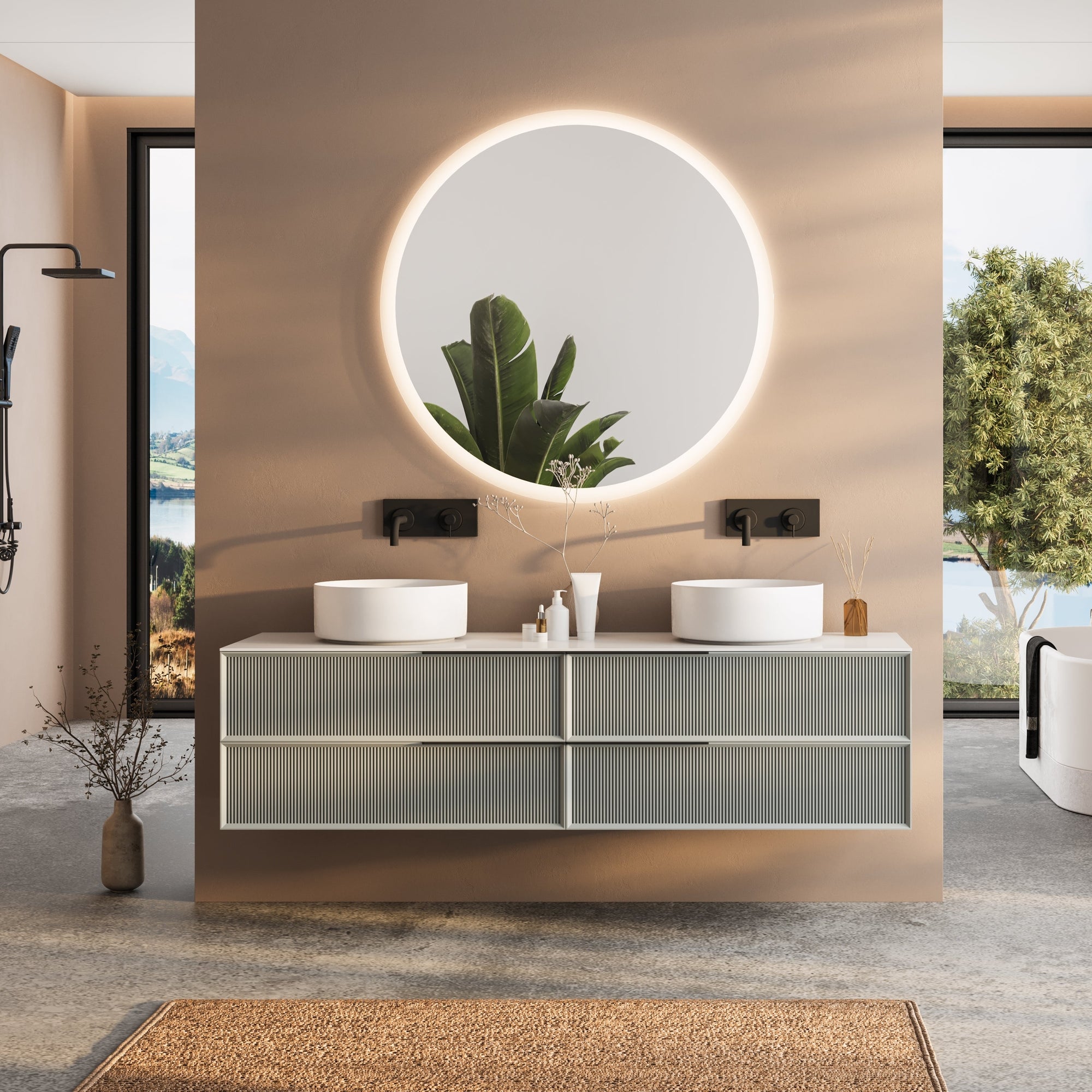 Ein großformatiger runder LED-Badspiegel von Spiegelmax mit sanfter, umlaufender Beleuchtung hängt über einem modernen Doppelwaschtisch mit zwei weißen Aufsatzbecken. Warme Wandtöne, ein strukturierter Waschtischunterschrank und minimalistisches Dekor schaffen ein hochwertiges Ambiente. Durch die großen Fenster links und rechts fällt Tageslicht ein, wodurch der beleuchtete Spiegel besonders hervortritt.