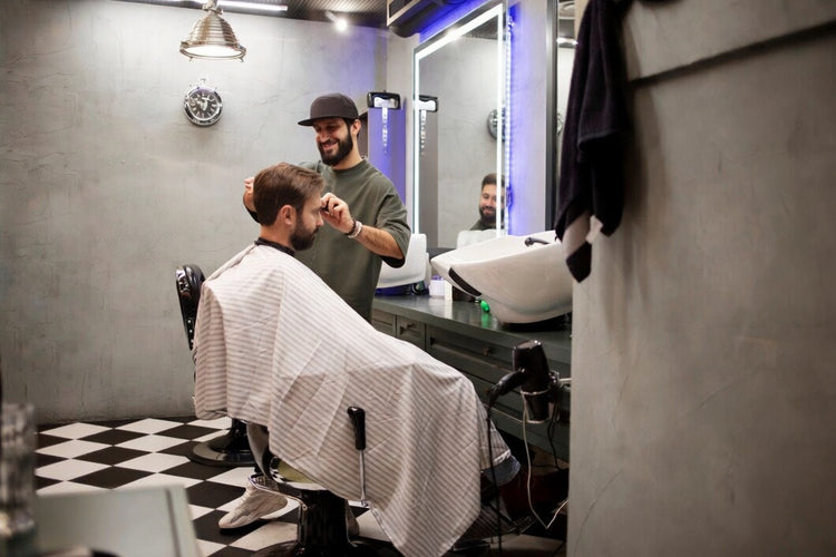 Barbershop mit beleuchtetem Friseurspiegel, Barberstuhl und professionellem Herrenhaarschnitt in modernem Salon-Ambiente
