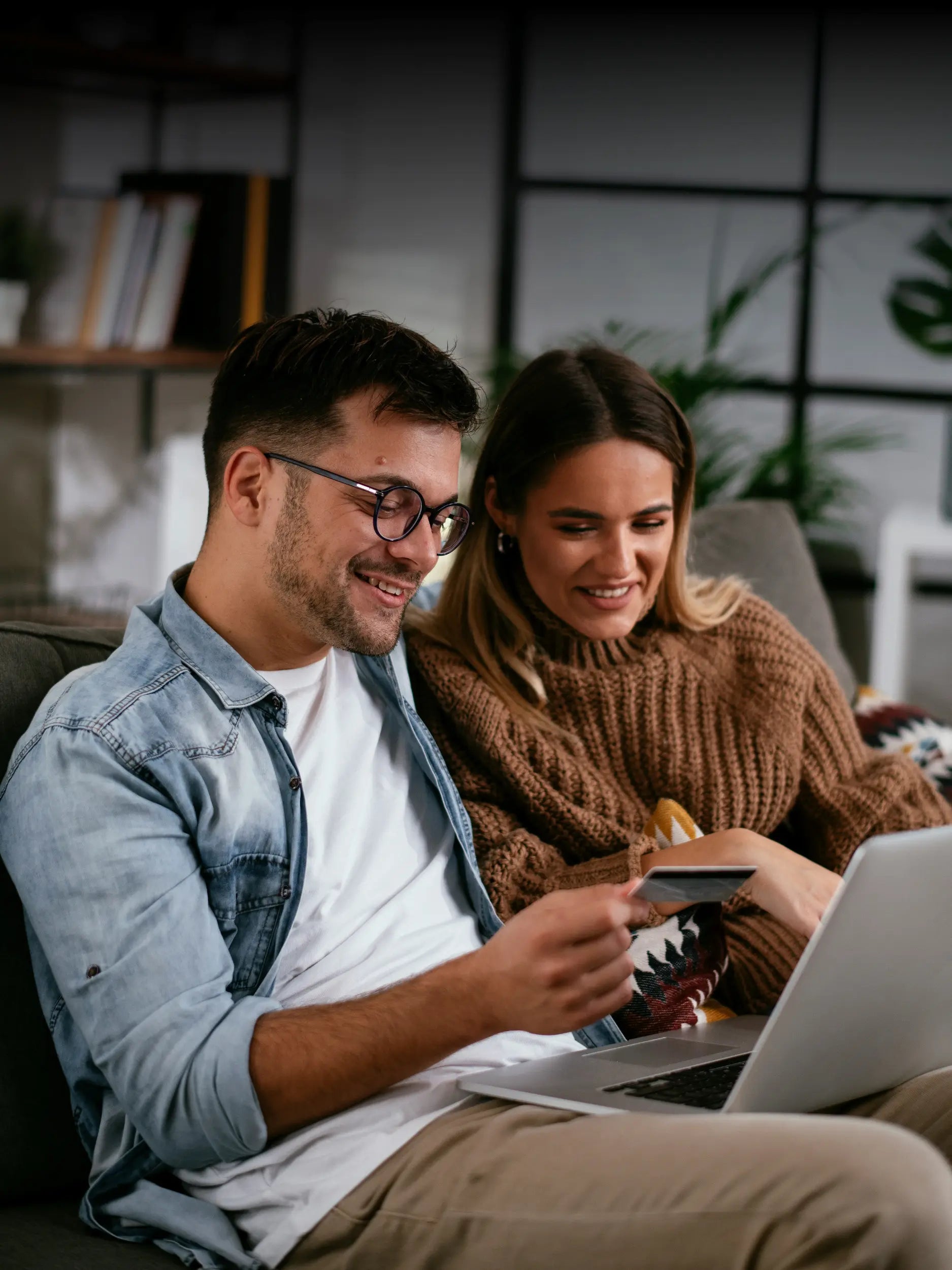 Kundinnen bestellen bequem maßgefertigte Spiegel oder Möbel online und bezahlen sicher per Kreditkarte am Laptop.