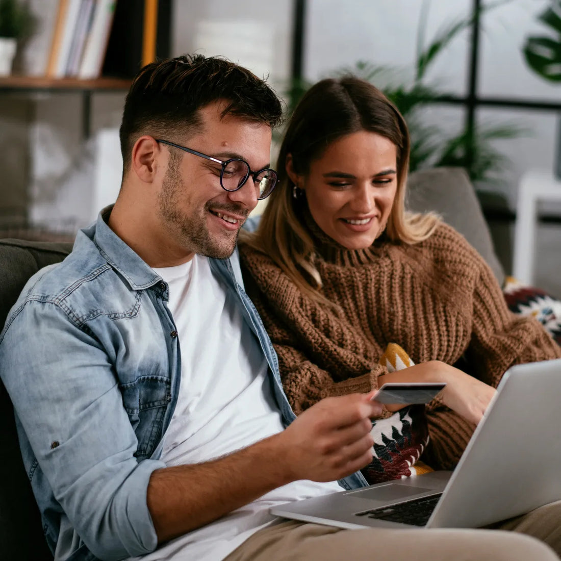 Zwei Personen tätigen gemeinsam eine Online-Bestellung für maßgefertigte Spiegel oder Möbel – schnelle und sichere Zahlung per Kreditkarte.