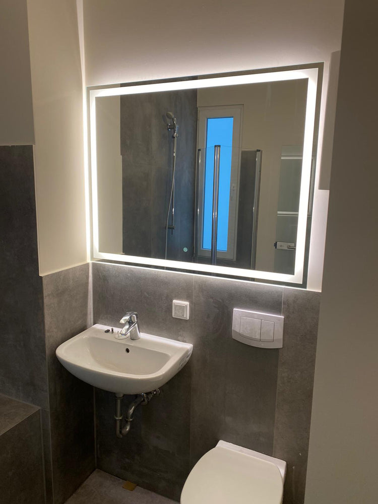 Rechteckiger LED-Lichtspiegel Bonn mit umlaufender Beleuchtung über Waschbecken im modernen Badezimmer.