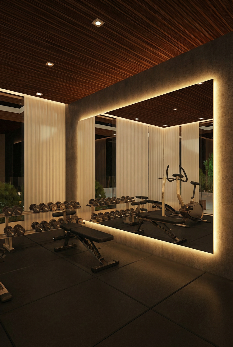 Eleganter Fitnessraum mit großer LED Spiegelwand, warmem Licht, Hantelbank, Kurzhanteln und hochwertiger Home-Gym-Ausstattung