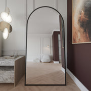 Rundbogen-Standspiegel Noir Mattschwarz, Frontansicht freistehend im Schlafzimmer.