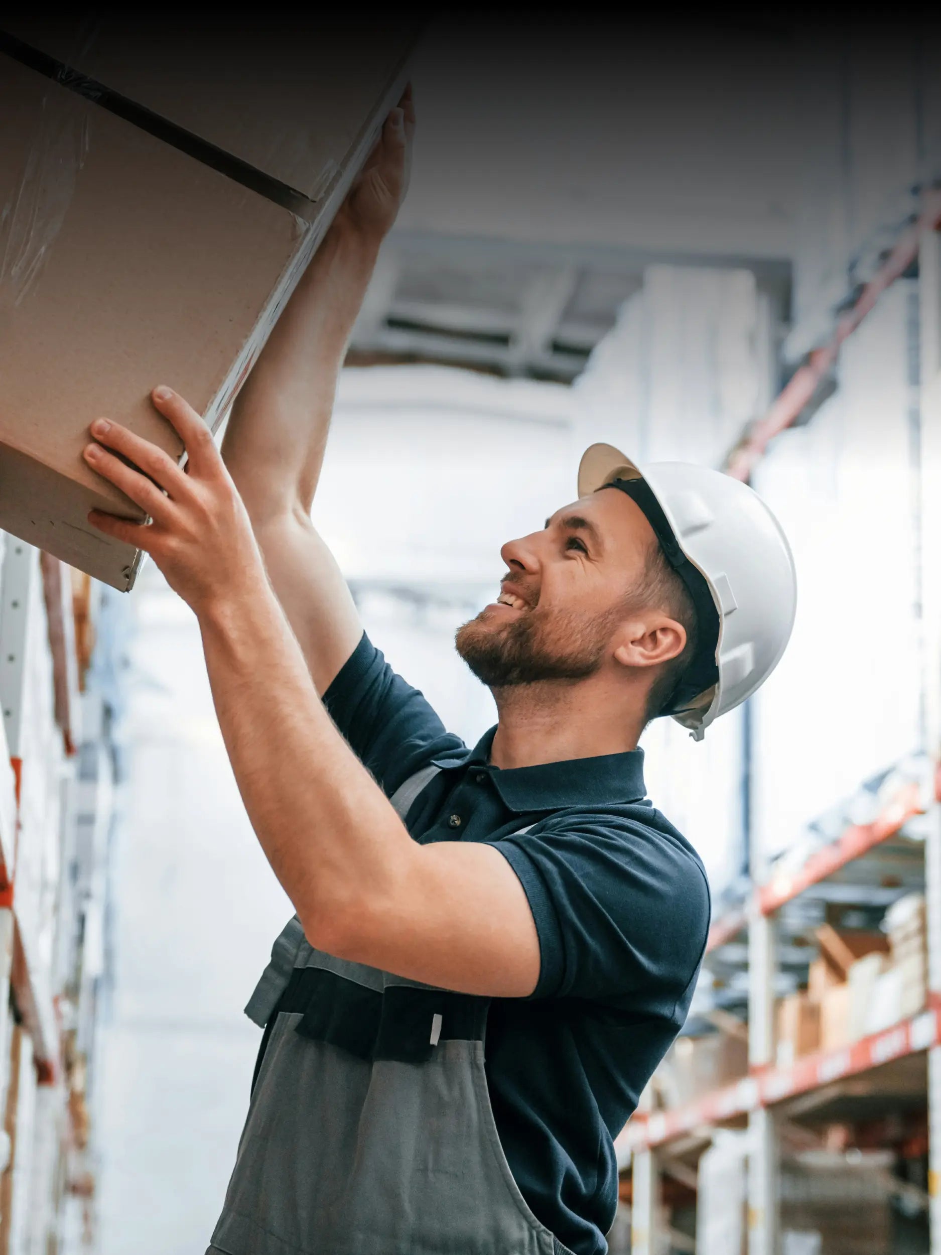 Lagerarbeiter hebt vorsichtig ein Paket mit handgefertigten Möbeln oder Spiegeln für den sicheren Versand.