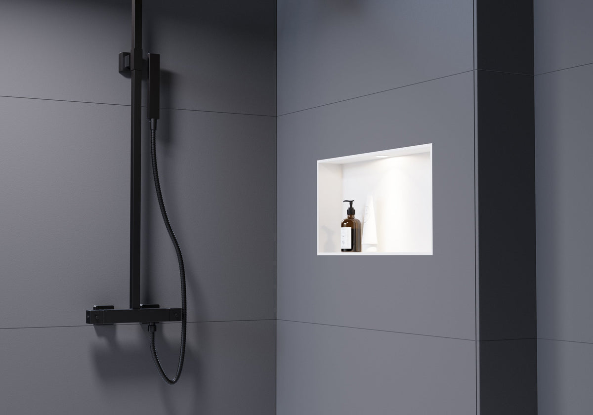 LED-Einbauspot beleuchtet ein kleines Wandregal in der Dusche.