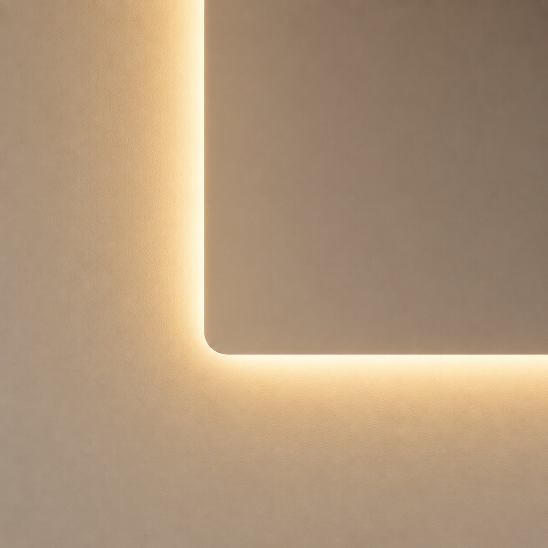 Warmweißer LED-Badspiegel mit abgerundeter Ecke und indirekter Beleuchtung an heller Badezimmerwand.
